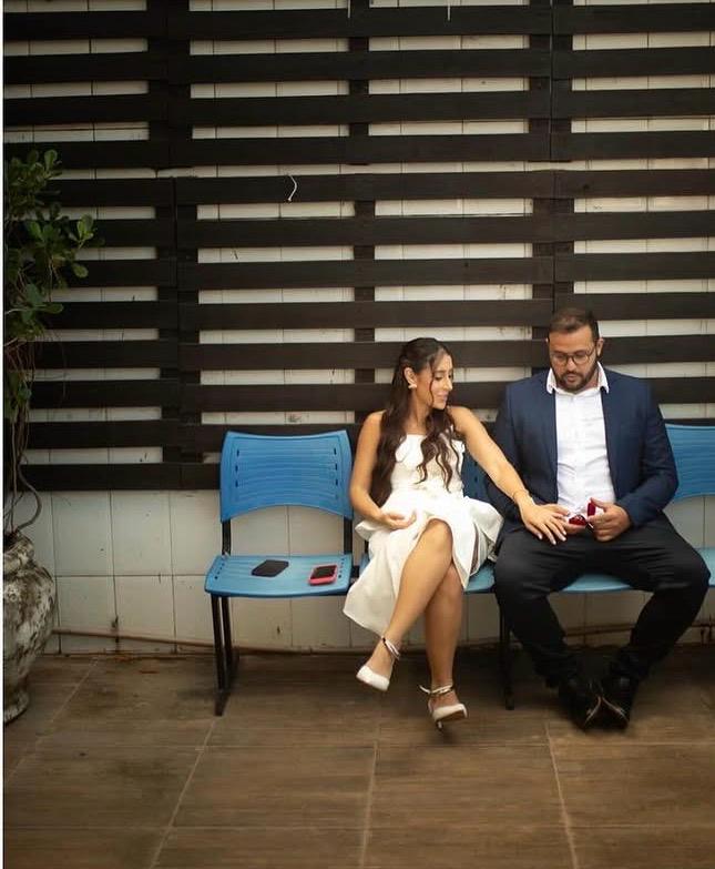 Nós dois, sentados lado a lado no banquinho azul, no dia do nosso casamento.